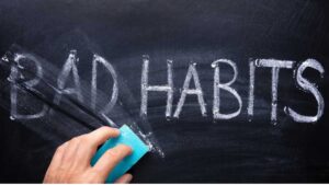 Erasing bad habits written on blackboard to show lifestyle change.