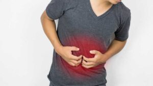 Person clutching stomach in discomfort – common signs of an unhealthy gut