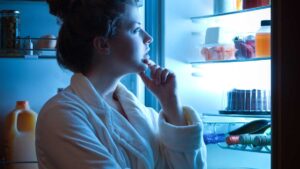 Person resisting late-night snacks to improve sleep and digestion.