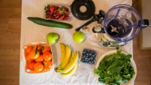 Assorted homemade smoothies ingredients with fresh fruits around them waiting to go in the best blenders for smoothies.