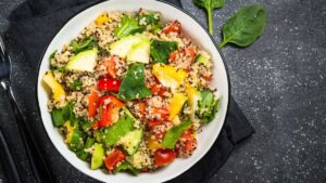Colorful quinoa and roasted veggie bowl with zucchini and olive oil, a nourishing gut-friendly lunch packed with fiber and antioxidants.