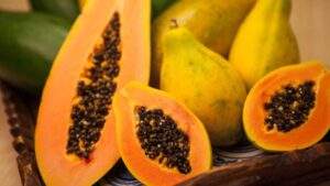 Papaya cut open with orange flesh and black seeds – tropical fruit aiding digestion with papain enzyme