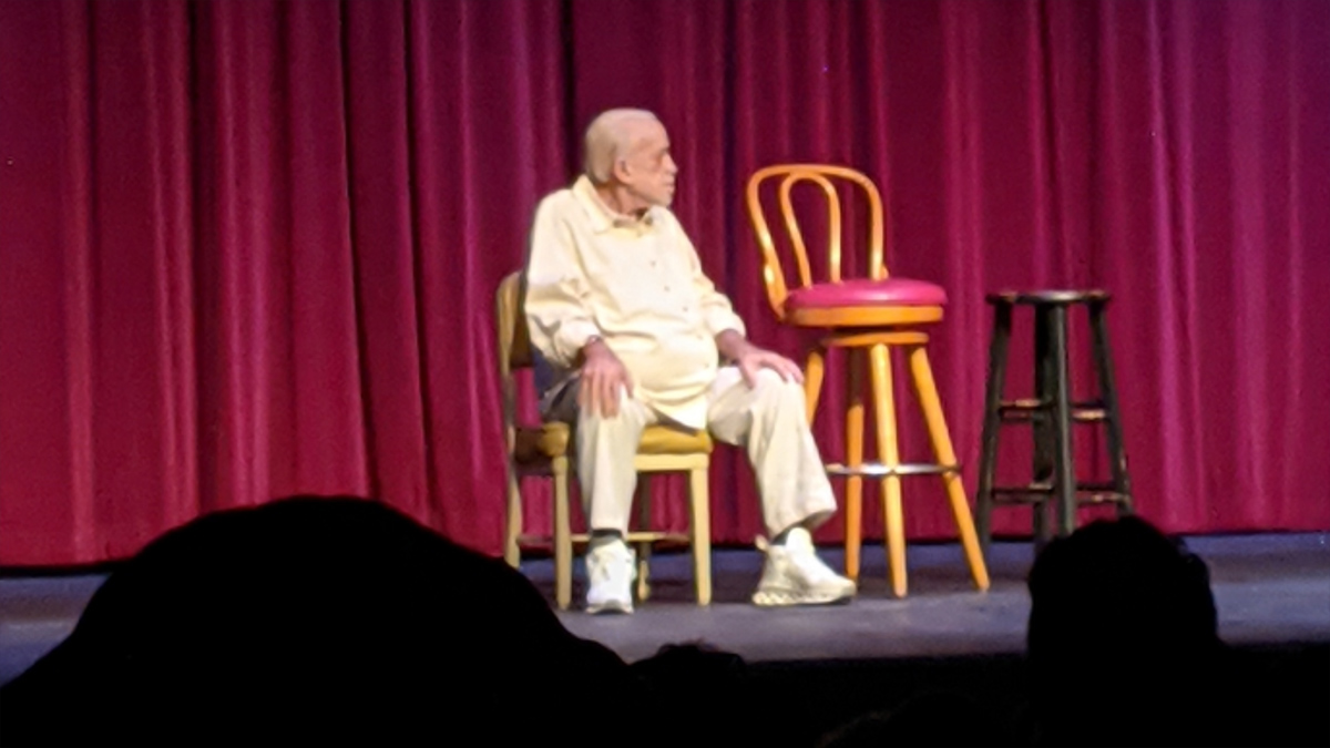 James Gregory after weight loss on the stage siting on a chair